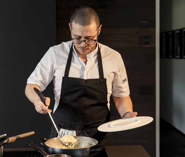 Luca Presti mentre cucina dal vivo davanti agli ospiti